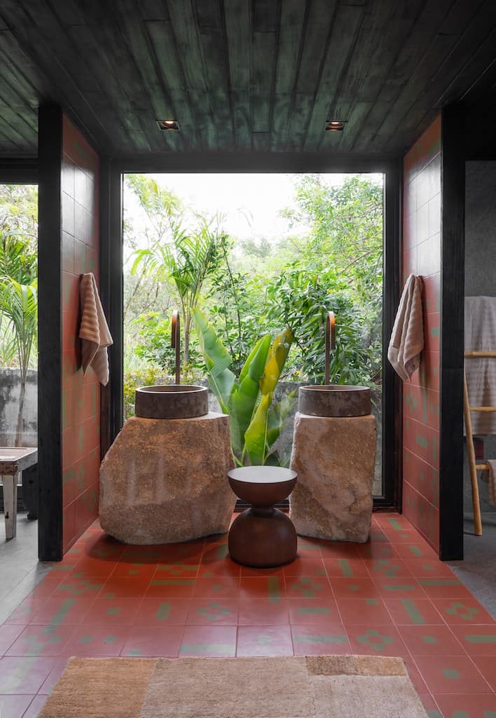 Vista da Reserva Ubud para a vegetação, com piso cerâmico e peças em madeira, na CASACOR SC Florianópolis 2026