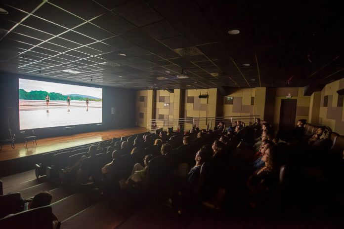 Público assiste a sessão de cinema em sala escura, imagem de divulgação do Festival Latino-Americano de Cinema Ambiental (FLACA)
