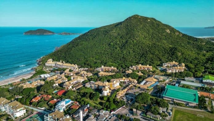 Vista aérea do Costão do Santinho Resort, com prédios entre a Mata Atlântica do Morro das Aranhas e a Praia do Santinho, em Florianópolis