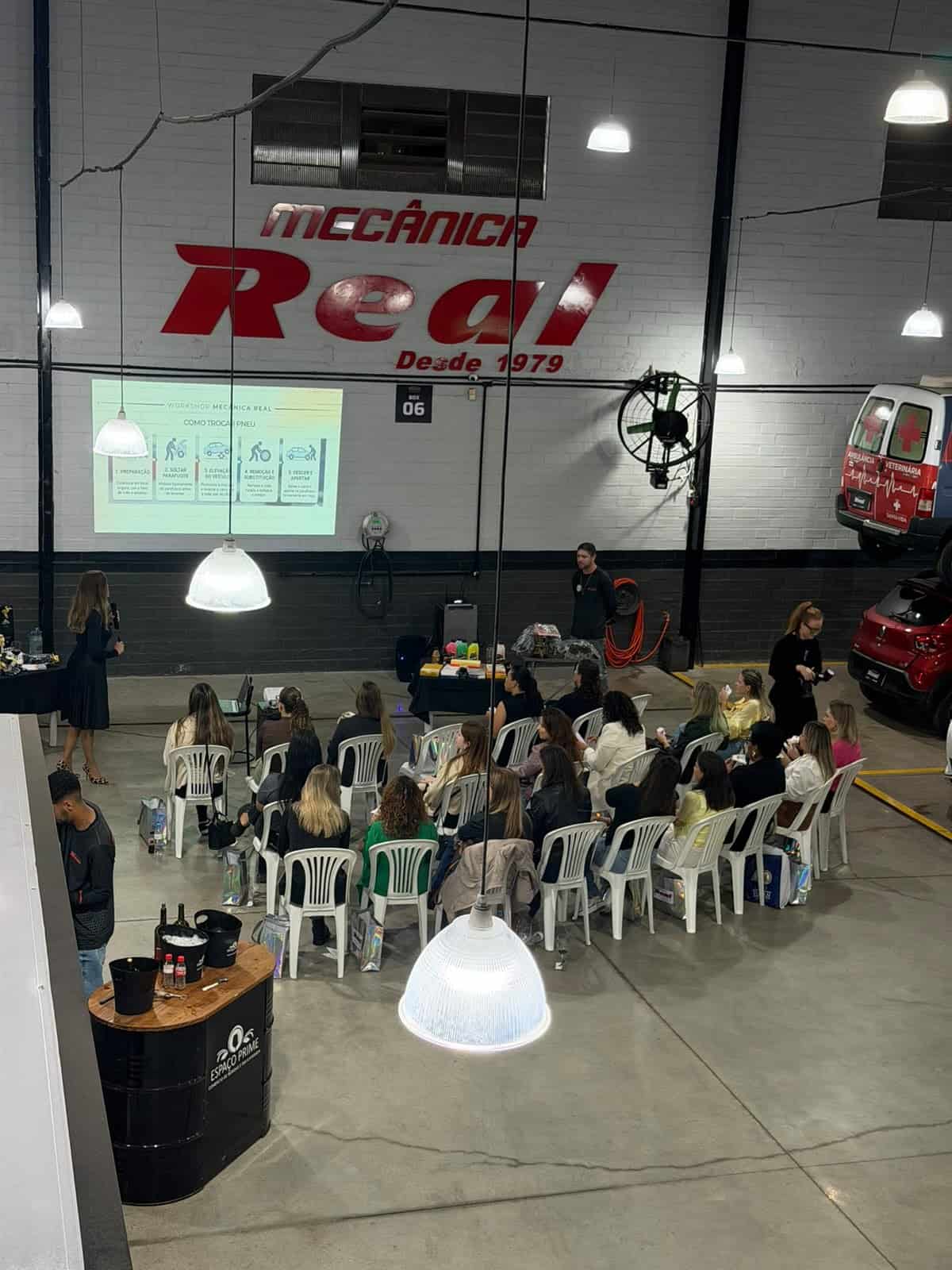 Mulheres acompanham apresentação durante a primeira edição do Workshop de Mecânica Básica para Mulheres, na Mecânica Real