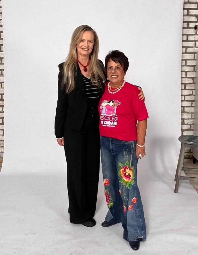 As professoras Neide Schulte e Icléia Silveira, do Ecomoda Udesc, em estúdio; uma delas veste calça jeans bordada com flores