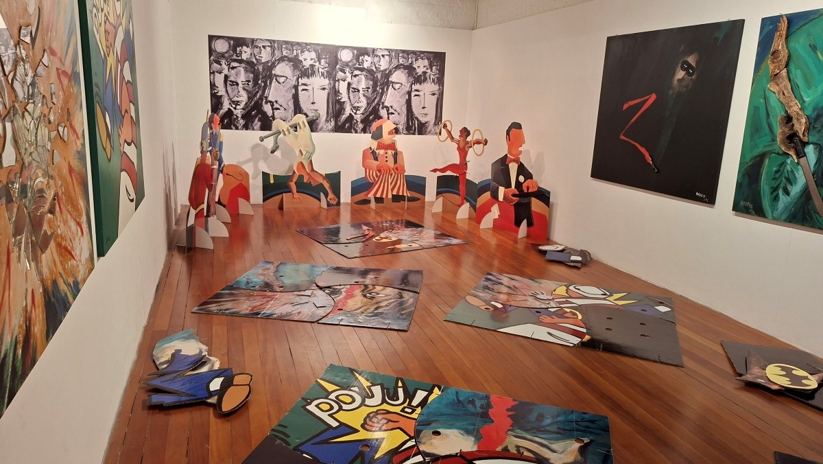 Sala da mostra Hassis Brincante, na Fundação Hassis, com obras coloridas nas paredes e tapetes no chão
