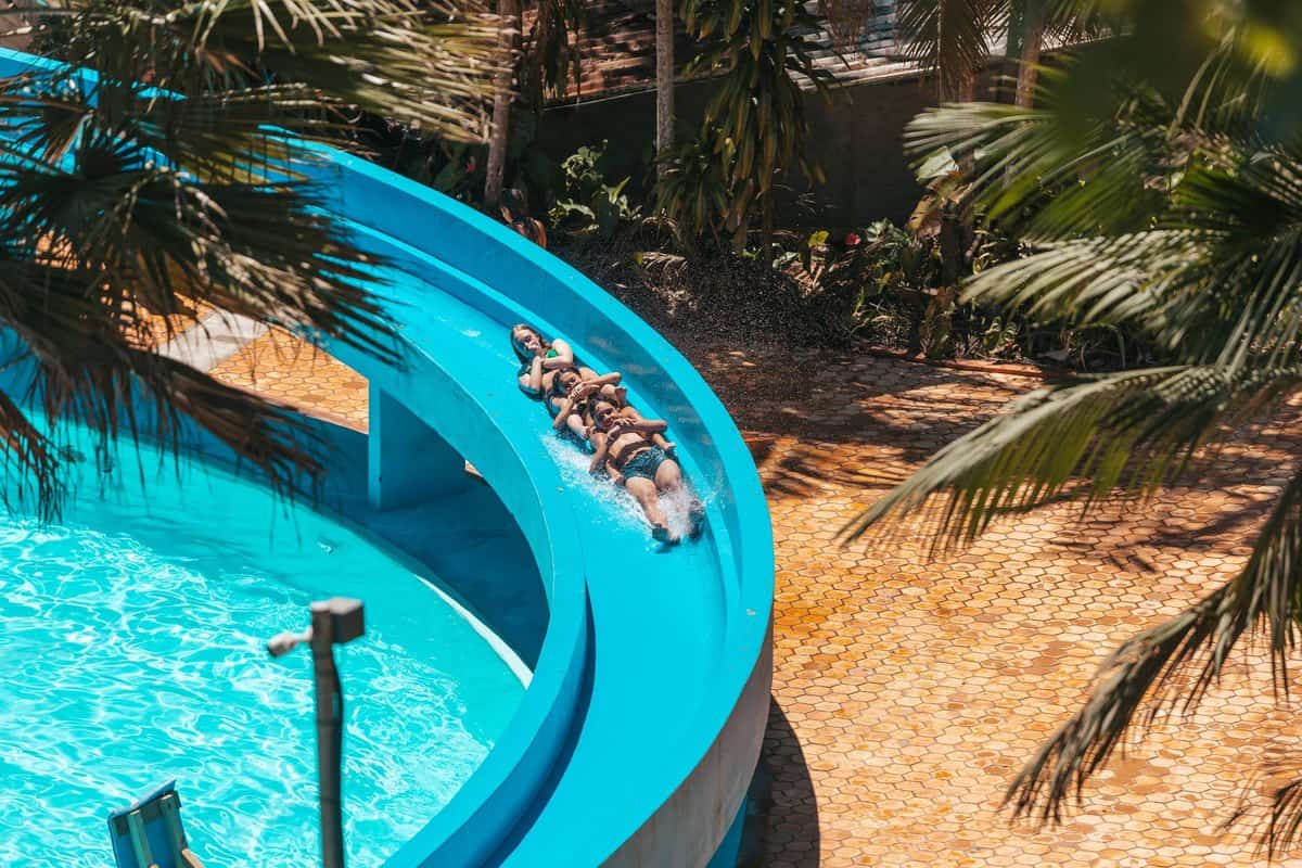 Visitantes descem um toboágua azul no Parque Aquático Cascanéia, em Gaspar