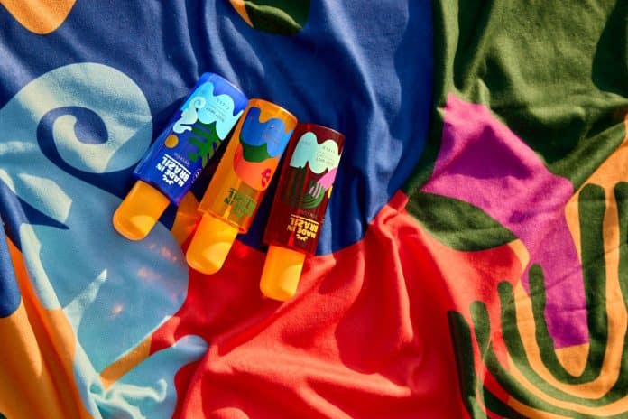 Três frascos de body mist da linha Made in Brazil, da Ciclo Cosméticos, sobre uma canga colorida