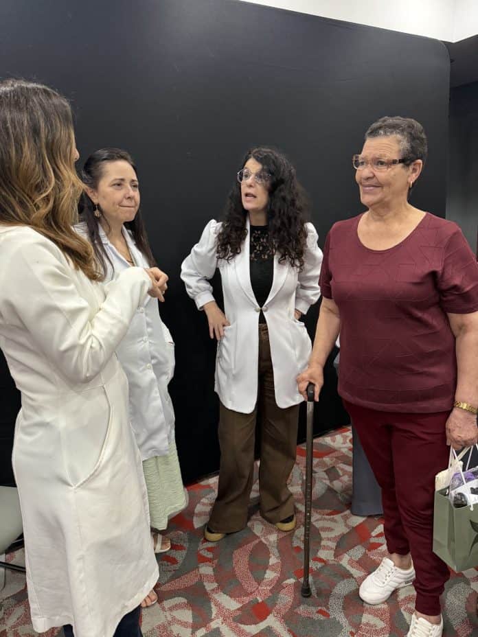 Profissionais de saúde conversam com participante em edição anterior da Clínica Prime Itinerante
