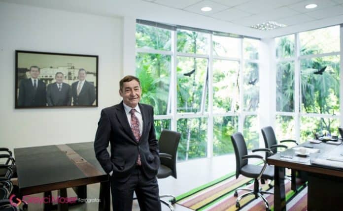 Décio da Silva, presidente do Conselho de Administração da WEG, de terno, em sala de reuniões com janelas de vidro