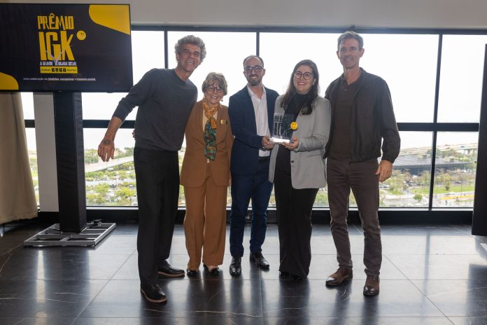 Gustavo, Alice e Rafael Kuerten posam com os professores Lucimara e João Paulo, que seguram o troféu do Prêmio IGK