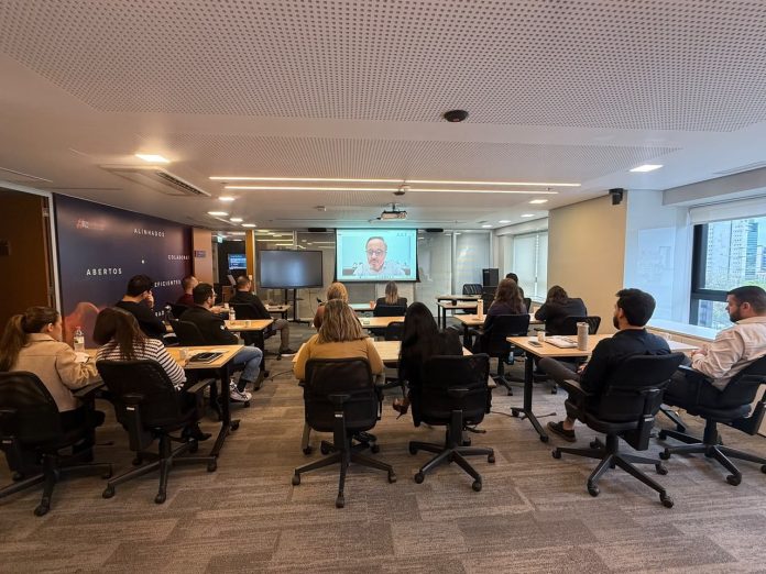 Colaboradores da Unicred reunidos em sala acompanham transmissão do CX Day em telão