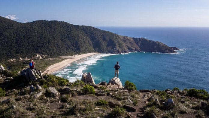 Vista da Praia da Lagoinha do Leste do alto da trilha, com dois caminhantes