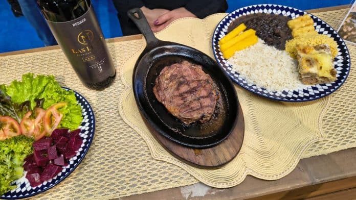 Prato de bife acompanhado de arroz, feijoada, farofa, salada e frutas servido em mesa de restaurante do Porto Belo Outlet Premium