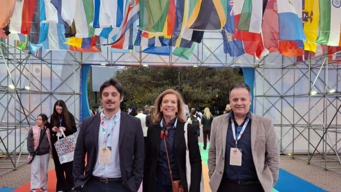 Representantes da Rede Plaza de Hotéis diante de bandeiras de vários países na FIT, em Buenos Aires