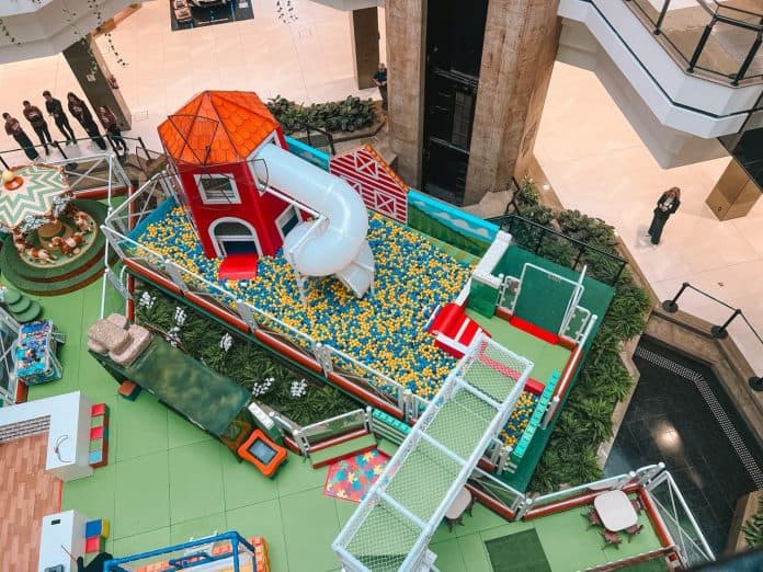 Vista do alto da Fazendinha no vão central do Beiramar Shopping, com celeiro vermelho, escorregador e piscina de bolinhas
