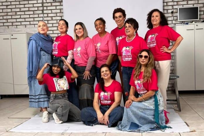 Mulheres com camisetas rosa do Outubro Rosa e peças de jeans posam em estúdio para o desfile do Ecomoda Udesc e da Amucc