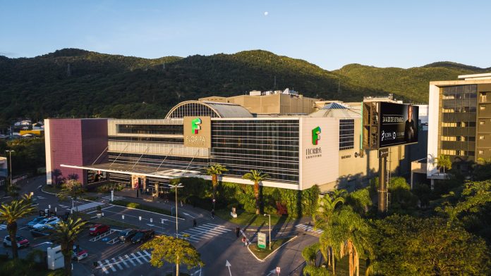 Vista aérea da fachada do Floripa Shopping, no Saco Grande, em Florianópolis, com morros ao fundo