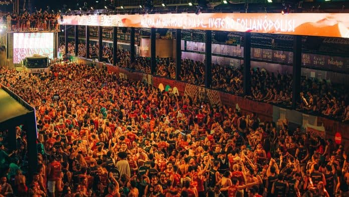 Multidão com abadás coloridos e mãos levantadas no Folianópolis, na Passarela Nego Quirido, em Florianópolis