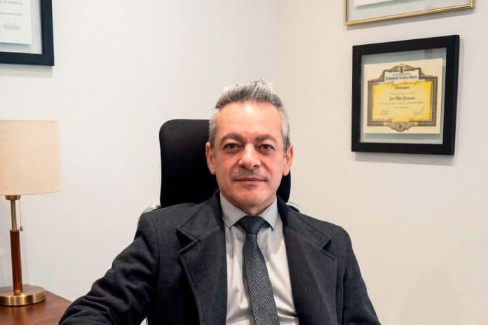 Roberto Cesar Pedrini, CEO da Ábaco Urbanizadora, de terno escuro e gravata, sentado em escritório
