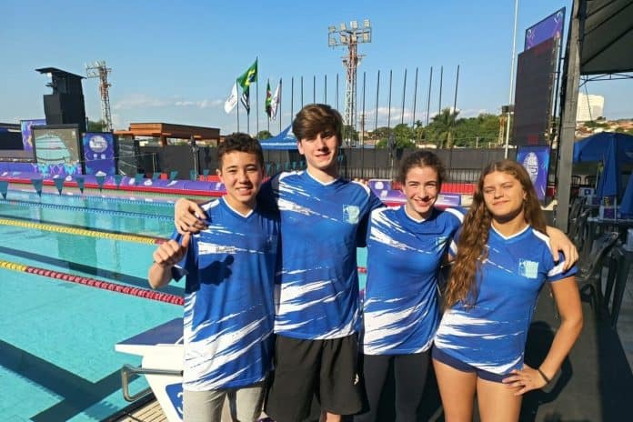 Quarteto de nadadores do Lira Tênis Clube com o uniforme da seleção catarinense à beira da piscina em Mococa (SP)