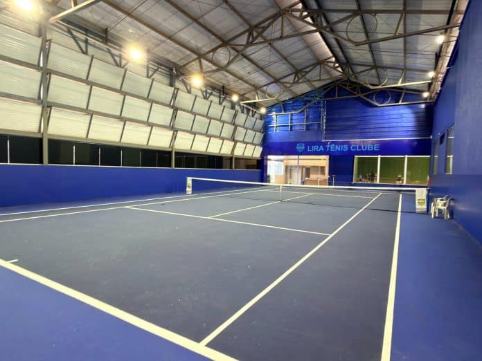 Nova quadra coberta de tênis do Lira Tênis Clube, com piso azul, rede montada e logotipo do clube na parede ao fundo
