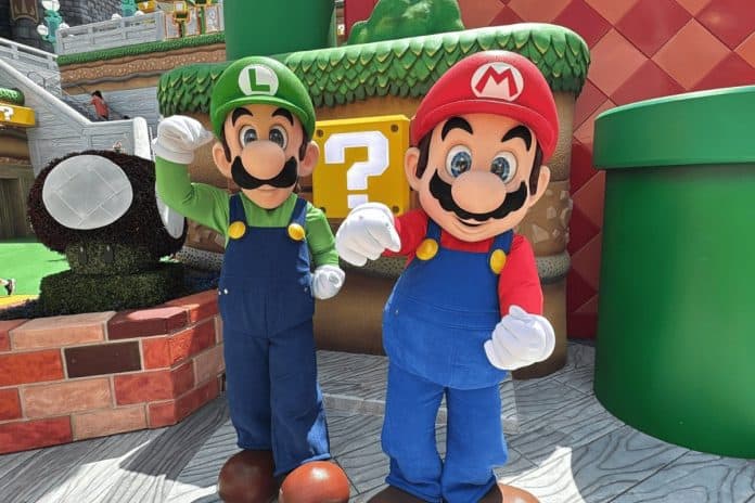 Personagens Mario e Luigi, do universo Super Mario, posam lado a lado em cenário temático