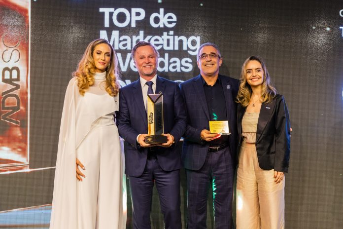 Representantes da Orsegups recebem o troféu do Prêmio Top de Marketing e Vendas 2026 da ADVB/SC no palco da cerimônia