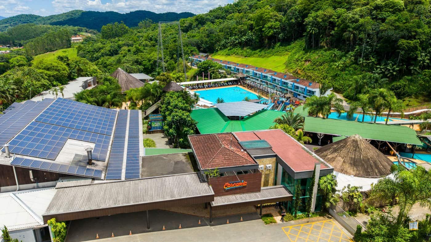 Vista aérea do Parque Aquático Cascanéia, em Gaspar, com piscinas, prédios e mata ao redor