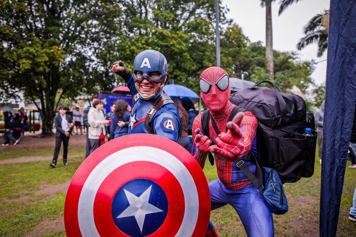 Cosplayers vestidos de Capitão América, com escudo, e de Homem-Aranha posam ao ar livre no Passeio Geek