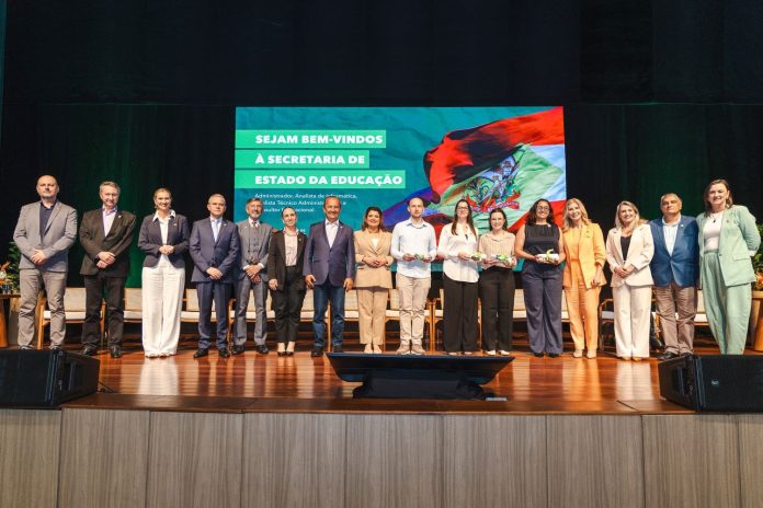 Novos servidores da Secretaria de Estado da Educação posam no palco com o governador Jorginho Mello durante cerimônia de posse em Florianópolis