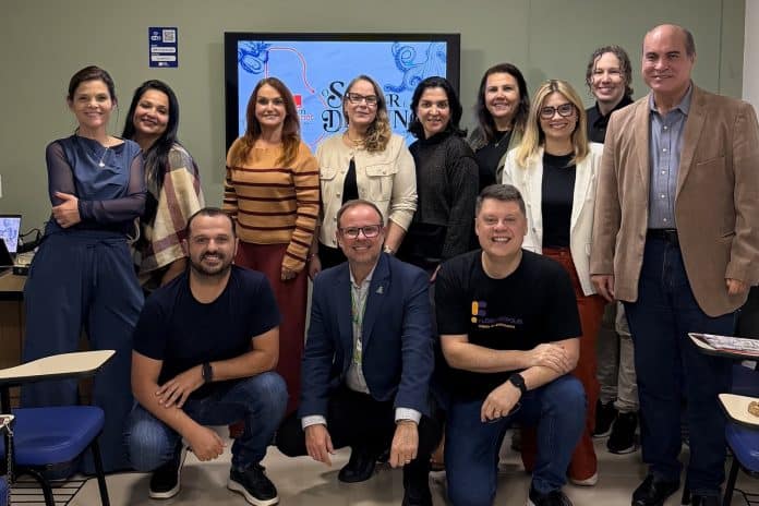 Grupo de jurados do Prêmio Bom Gourmet Santa Catarina posa em sala de reunião em Florianópolis, com tela ao fundo