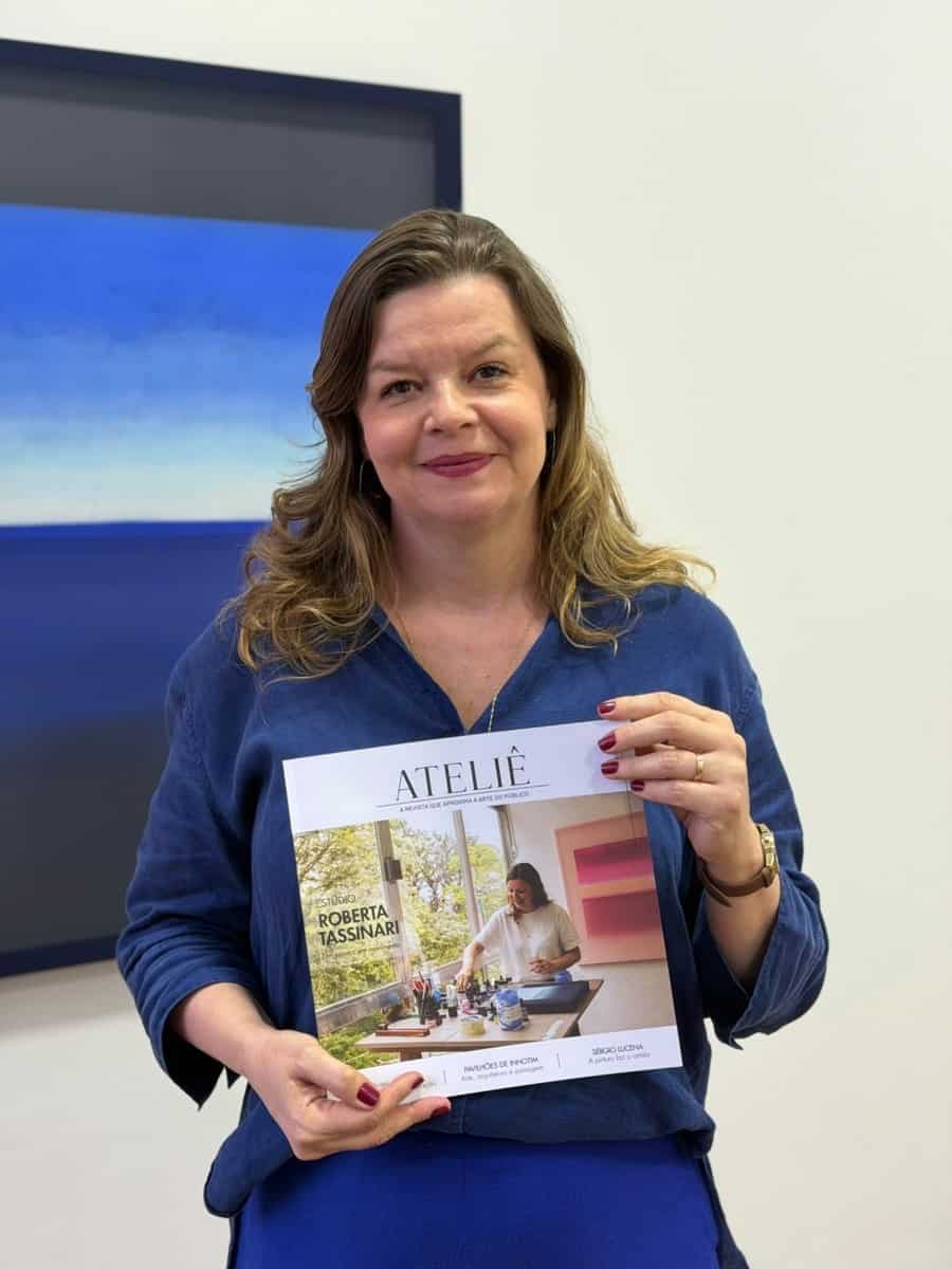 A artista Roberta Tassinari segura a terceira edição da Revista Ateliê