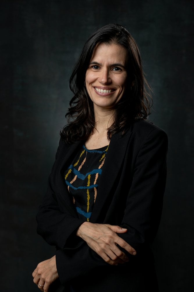 Thais Soares, diretora de Sustentabilidade da ENGIE Brasil, sorrindo em retrato com fundo escuro