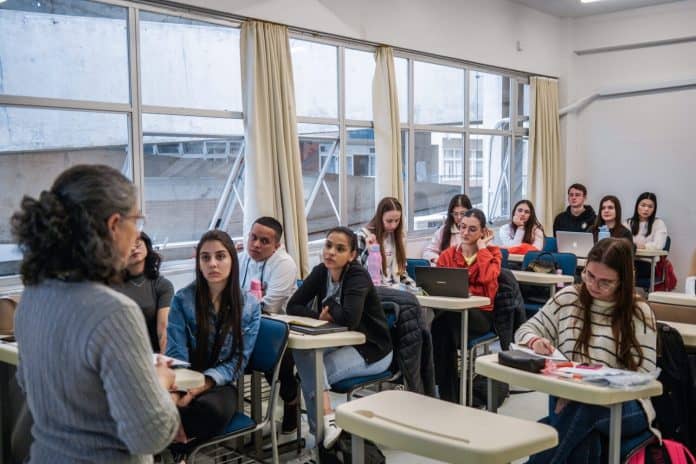 Professora fala a estudantes universitários em sala de aula em Santa Catarina