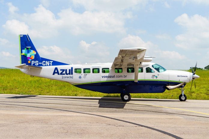 Avião Cessna Caravan da Azul Conecta, pintado de branco e azul, parado na pista de um aeroporto regional